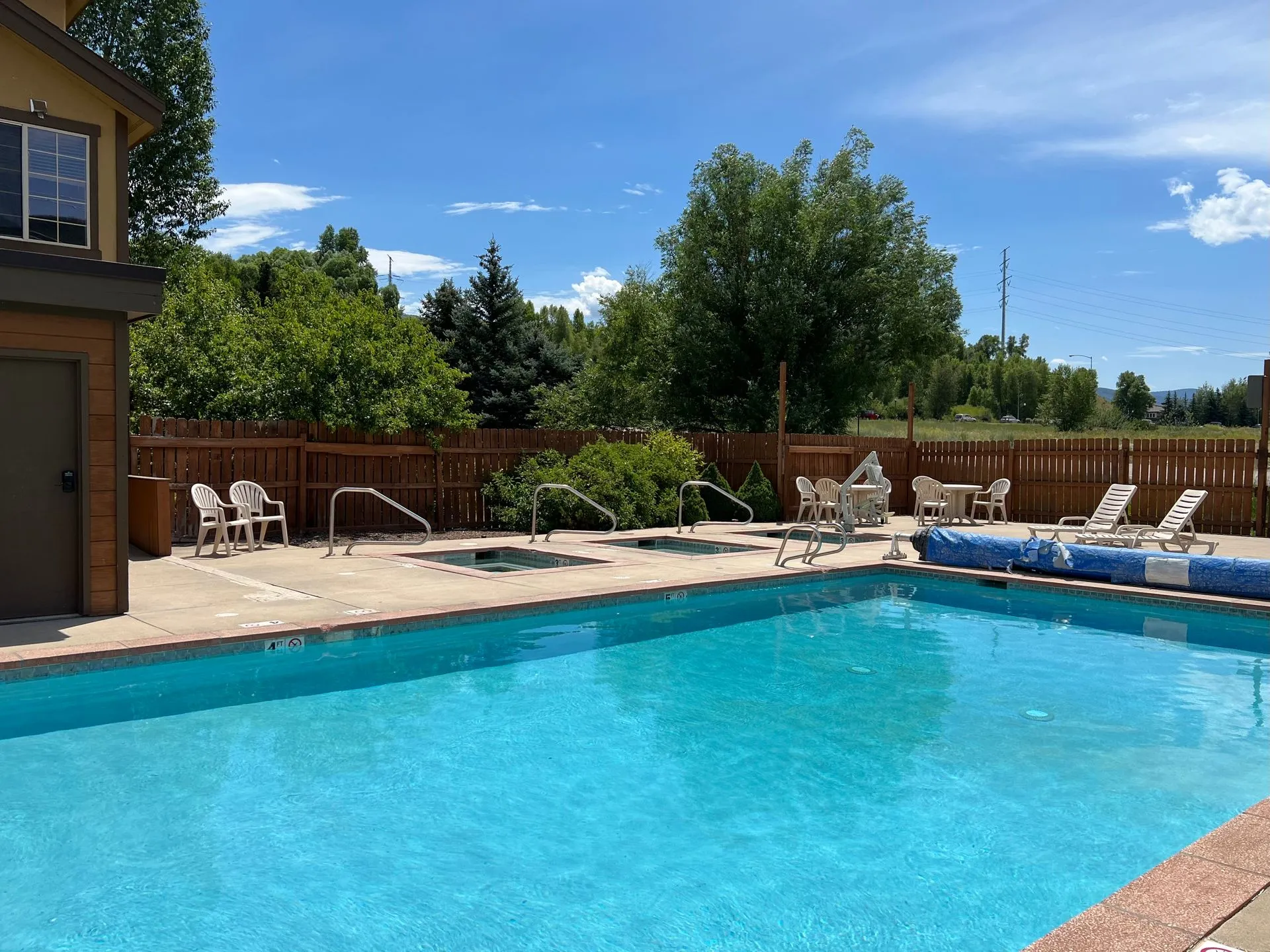 Outdoor swimming pool with mountain backdrop at Ski Town Apartments